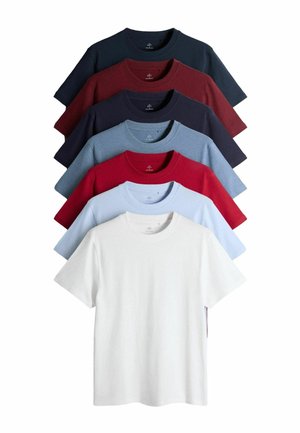 Sept t-shirts à col rond pliés, en marine, bordeaux, bleu foncé, bleu clair, rouge, bleu pâle et blanc, disposés en éventail empilé.