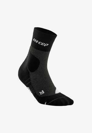 Schwarze Sportsocke mit geripptem Bündchen, feuchtigkeitsableitendem Material, gepolstertem Fersen- und Zehenbereich sowie kontrastierendem weißen Logo und Streifen.