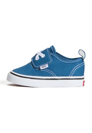 Zapato para niños pequeños Vans azul con cordones blancos, suela blanca, franja negra y tira para tirar en el talón, mostrado de lado sobre fondo blanco.