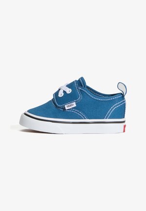 Kék Vans kisgyermek cipő fehér fűzőkkel, fehér talppal, fekete csíkkal és a saroknál húzófüllel, oldalnézetben, fehér háttéren.