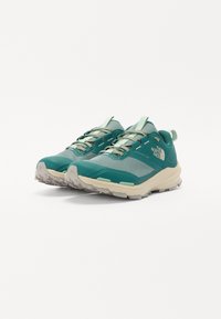 Teal trail running shoes with mesh upper, light green accents, and durable rubber outsole. Features reinforced toe and cushioned midsole.