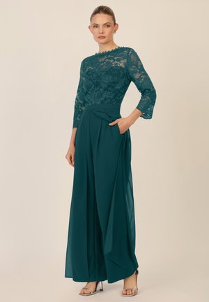 Teal jumpsuitki, lace bodice, kolmekvartalsete varrukatega ja pleatitavate laiade pükstega. Küljel on tasku ja sile satiinini tekstuur.