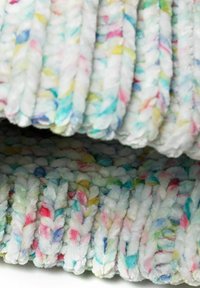 Weiches, plüschiges Gewebe im geflochtenen Design; überwiegend weiß mit mehrfarbigen Pastellakzenten in Rosa, Blau und Gelb.