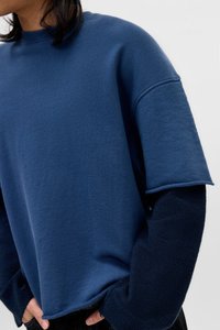 Marineblaue übergroße Sweatshirt mit kurzen Ärmeln, weicher Textur, geripptem Halsausschnitt und kontrastierenden dunkleren langen Ärmeln. Lässige Passform.