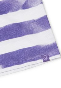 Purple and white striped fabric, featuring soft cotton texture. Small tag in the bottom corner with logo. Pattern alternates between wide and narrow stripes.