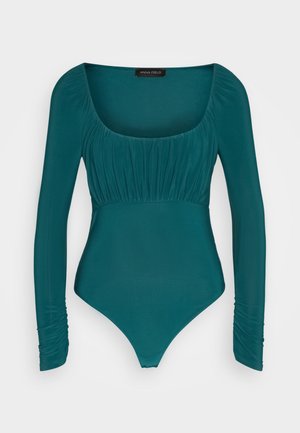 Τελινού μπλουζάκι με μακρύ μανίκι σε τιρκουάζ χρώμα, με τετράγωνη λαιμόκοψη, ραφές στη θήκη και εφαρμοστή σχεδίαση. Μαλακή, λεία υφή.