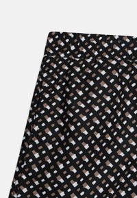 Tissu noir avec un motif géométrique de formes entrelacées en marron et blanc. Taille élastique avec une texture lisse ; design décontracté.