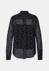 Zwarte doorschijnende blouse met lange mouwen en kleine blauwe bloemenprint, van achteren gezien tegen een witte achtergrond.