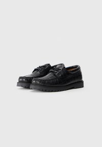 Black leather shoes with a textured, crocodile pattern. Features rounded toe, lace-up design, and thick, rugged sole.
