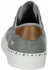 Sneaker en toile grise avec un accent de talon en cuir marron, semelle extérieure blanche et coutures rouges. Présente un petit logo sur le côté.