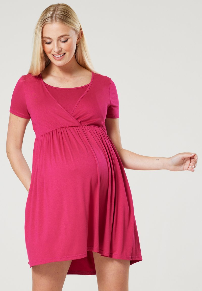 Pink maternity dress with a wrap design, short sleeves, and a gathered waist for comfort. Made from soft, stretchy fabric.
