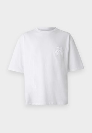 White cotton t-shirt with a relaxed fit, round neckline, and short sleeves. Features a subtle embroidered design on the left chest area.