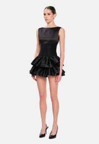 Vestido de satén negro con corsé ajustado y falda de volantes en capas. Presenta un escote barco y diseño sin mangas. Textura suave en todo el vestido.