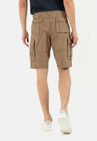 Khaki cargo shorts with multiple side pockets, elastic waistband, and a relaxed fit. Smooth fabric texture and knee-length cut.