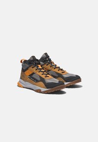 Wanderschuhe in einem Schwarz-, Grau- und Orangefarbenschema. Sie verfügen über ein atmungsaktives Mesh-Obermaterial, eine Gummisohle und eine verstärkte Zehenkappe.