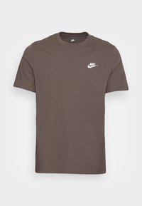 Brun bomull T-shirt med rund hals och korta ärmar. Har en vit Nike-logotyp på vänster bröstområde. Enkelt mönster, inga mönster.