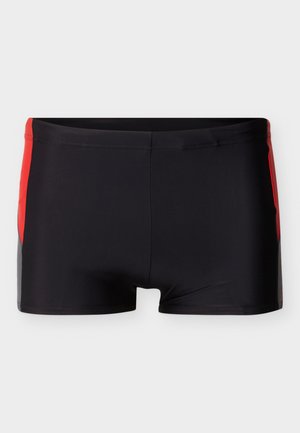 Zwarte zwembroek voor mannen met rode zijpanelen, vierkante snit en een elastische tailleband, weergegeven tegen een lichtgrijze achtergrond.