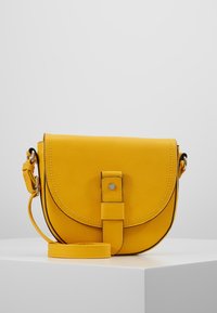 Borsa a tracolla in pelle gialla con pattina arrotondata, chiusa da un bottone a pressione, dotata di tracolla regolabile e dettagli cuciti.