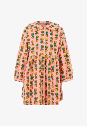 Abito rosa con un motivo cubico giocoso in verde, giallo e rosso. Maniche lunghe, chiusura con bottoni e colletto arricciato. Orlo svasato.