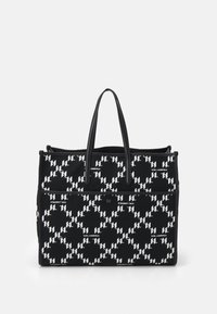 Sac fourre-tout en tissu noir avec un motif de logo blanc répétitif. Il est doté de deux poignées robustes et d'une poche avant zippée.