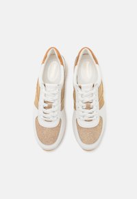 Balti sportbačiai su metalizuotais aukso akcentais, tekstūruota medžiaga ir plokščiomis raištelėmis. Turi apvalų nosį ir paminkštintą baltą pado dalį.