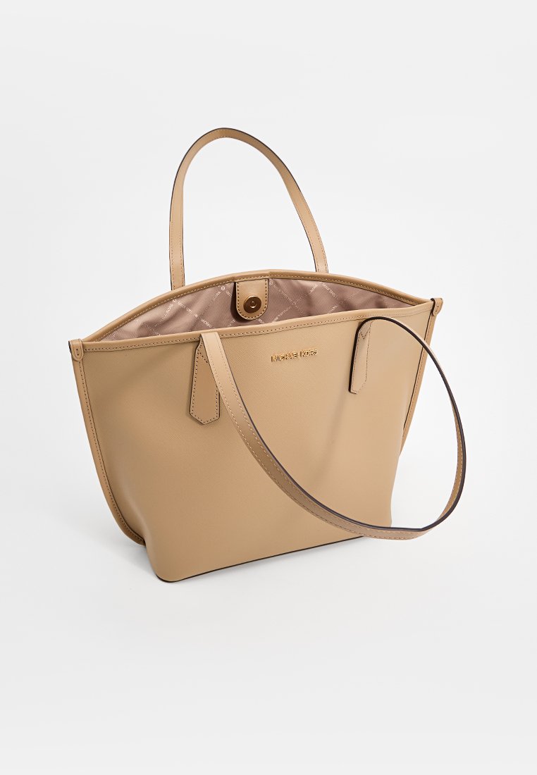 Borsa a tracolla in pelle beige con due manici, base piatta e chiusura magnetica. L'interno presenta una fodera decorata e un logo di marca.