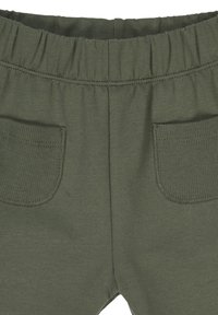 Pantaloni in cotone verde oliva con vita elasticizzata, dotati di due tasche posteriori e una texture morbida e liscia.
