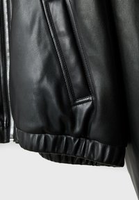 Veste bomber en cuir noir présentant une texture lisse, des poignets côtelés et une poche latérale avec une fermeture éclair.