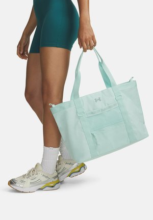 Licht muntgroene draagtas met een voorvak van mesh en logo detail. Gemaakt van duurzaam materiaal met stevige handgrepen.