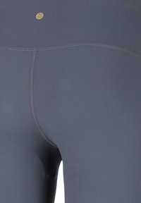Leggings a vita alta di colore blu navy realizzati in tessuto morbido e elastico. Presentano cuciture flatlock e un piccolo logo dorato vicino alla vita.