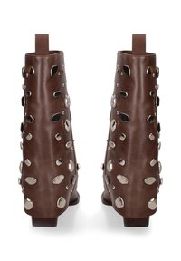 Bruine leren enkelboots met zilveren metalen studs die de achterkant en zijkanten bedekken, voorzien van lage gestapelde hakken en aantrek- lussen.