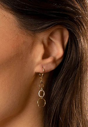 Goldene Tropfohrringe mit drei miteinander verbundenen Ringen; zwei glatte goldene Ringe und einer mit kleinen klaren Kristallen verziert.