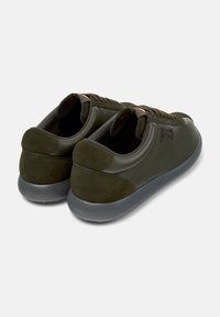 Dark olive green sneakers with a smooth leather body, suede accents, and a rounded rubber sole. Features contrasting stitching and logo detailing.