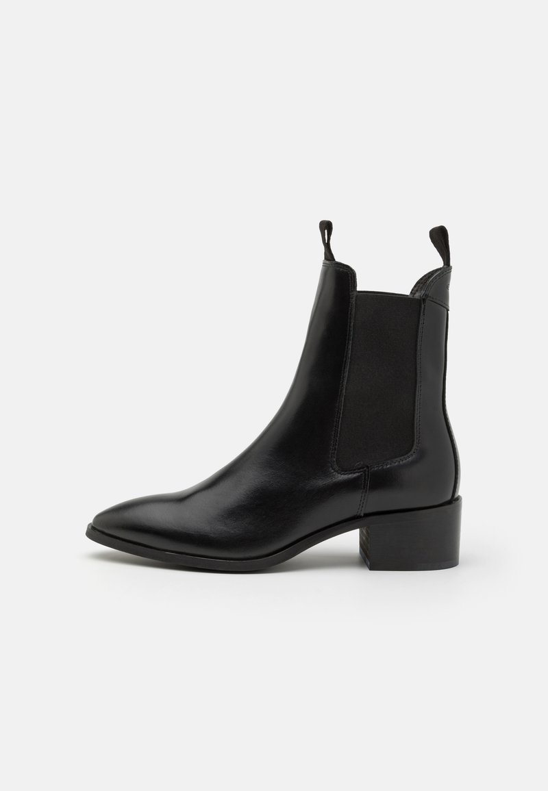 Black leather ankle boot with pointed toe, elastic side panels, pull tabs, and low block heel on white background.