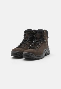Bruine wandelschoenen van suede en synthetische materialen, met hoge enkelsteun, rubberen zolen en zwarte veters. Voorzien van metalen oogjes.