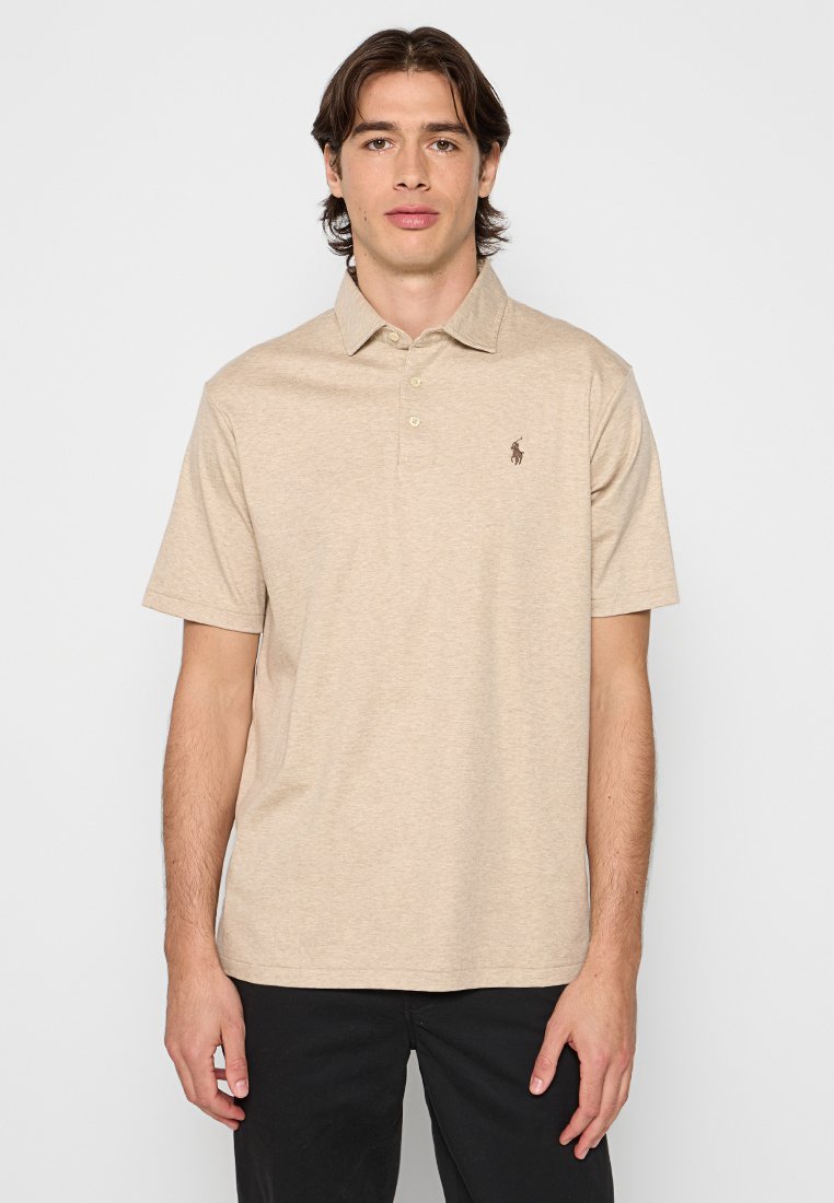 Polo beige en coton doux, avec un col à trois boutons et un petit logo sur la poitrine gauche. Manches courtes et coupe décontractée.