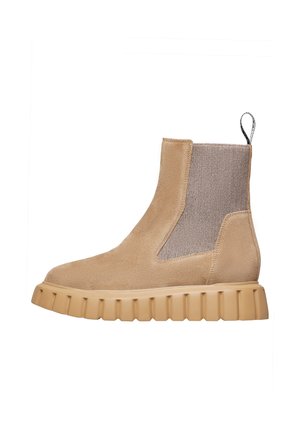 Beige suede ankle boot with stretchy beige knit panel, chunky rubber sole, and pull tab at the back; minimalistic design and texture contrast.