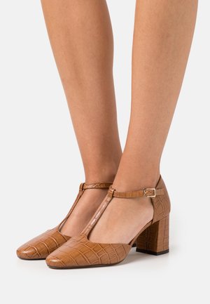 Ruske faux nahkave T-sandalit, koji imaju teksturu krokodila, kvadratni vrh i blok petu; sadrže detalj sa strane na kopčanje.