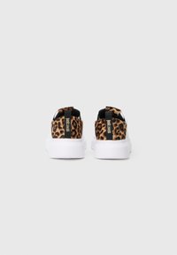Bijele tenisice s detaljima od leopard printa na peti i crnim povlačnim trakama s oznakom "Just Cavalli", pogledano s leđa.