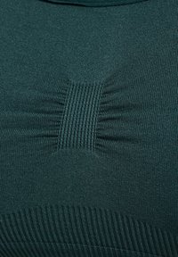 Donkergroen geribd stof met een textuurrijke accent in het midden en een gladde rand. Het ontwerp heeft verticale lijnen en subtiele plooien.