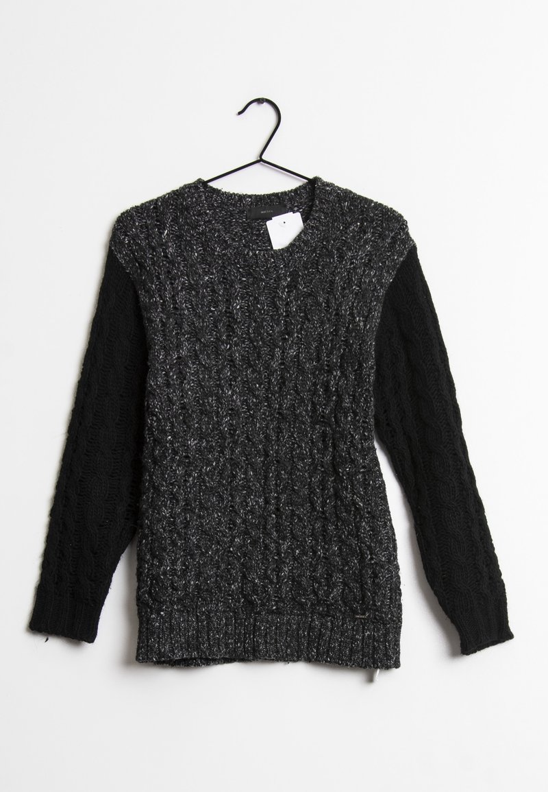 Pull en maille torsadée gris foncé avec manches noires suspendu à un cintre noir sur fond blanc.