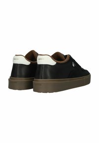 Sneakers neri con tomaia in pelle liscia, dettagli in camoscio e suola in gomma marrone. Presentano un'etichetta sul tallone bianca e dettagli di branding discreti.