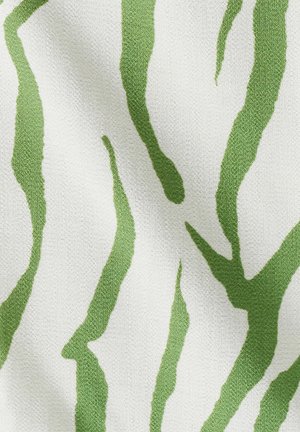 Tissu tissé vert et blanc présentant des rayures irrégulières imitant un motif zébré ; la surface texturée met en valeur le design.