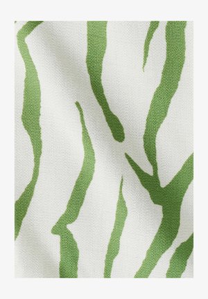 Tissu tissé vert et blanc présentant des rayures irrégulières imitant un motif zébré ; la surface texturée met en valeur le design.