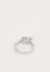 Anello in metallo argentato con un design dettagliato, impreziosito da piccoli gemme trasparenti lungo la fascia e un motivo decorativo prominente sulla parte superiore.