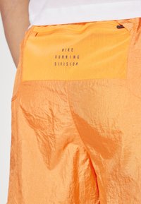 Nike Performance RUN STRIDE - Pantalón corto de deporte - bright mandarin/black