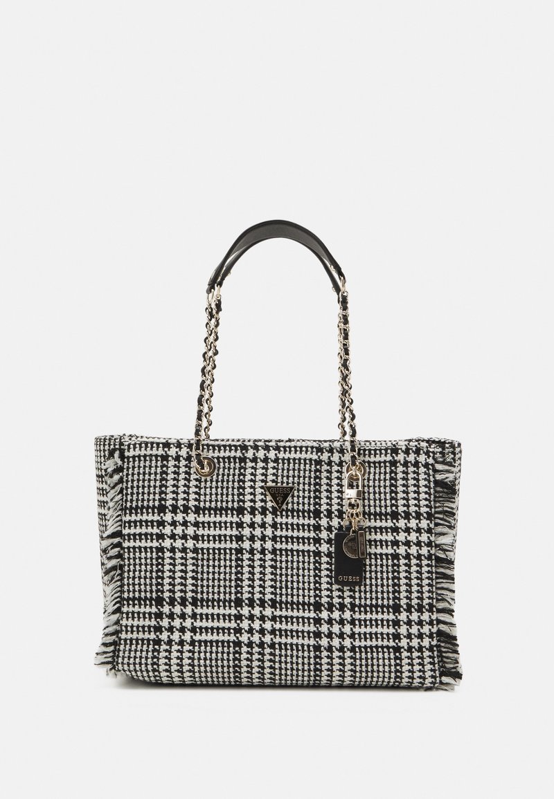 Sac cabas à motif pied-de-poule noir et blanc avec anses chaîne et logo GUESS avec pendentif sur le devant.