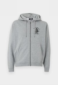 Ανοιχτό γκρι φούτερ με φερμουάρ, κορδόνια, εμπρόσθιες τσέπες και μικρό μαύρο γραφικό σχέδιο στο αριστερό πάνω μέρος του στήθους.