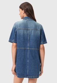 Robe en denim bleu moyen, à manches courtes, collerette avec un design de panneau cousu, présentant une coupe droite et un ourlet net.