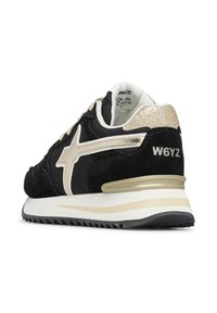 Sneaker in suede nero e tessuto con accenti dorati, suola chunky, collare imbottito e branding "W6YZ" sul retro.